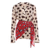Beige blouse with brown polka dots and red skirt with white polka dots on a white background